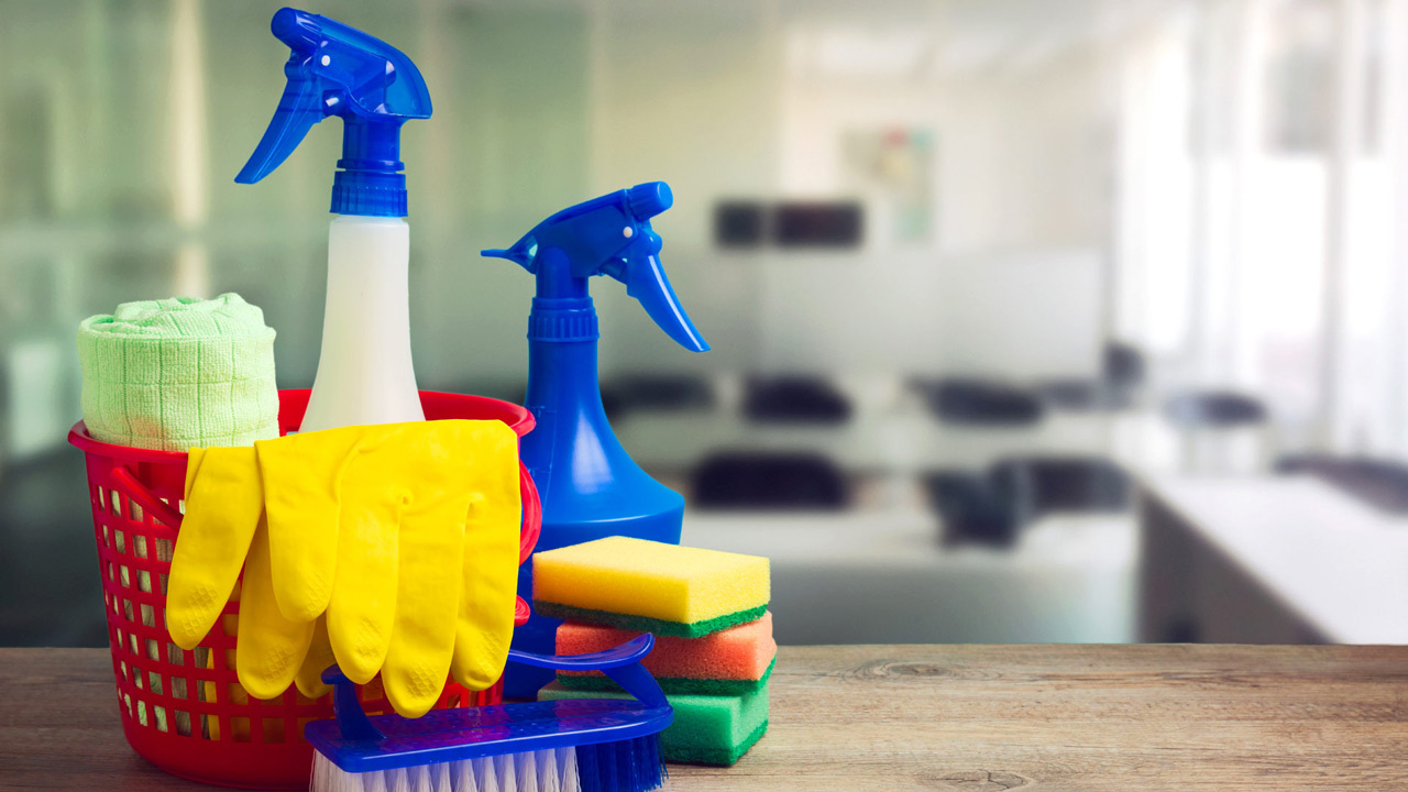 Cleaning supplies neatly arranged in a basket on a table, ready for use in maintaining a tidy space.